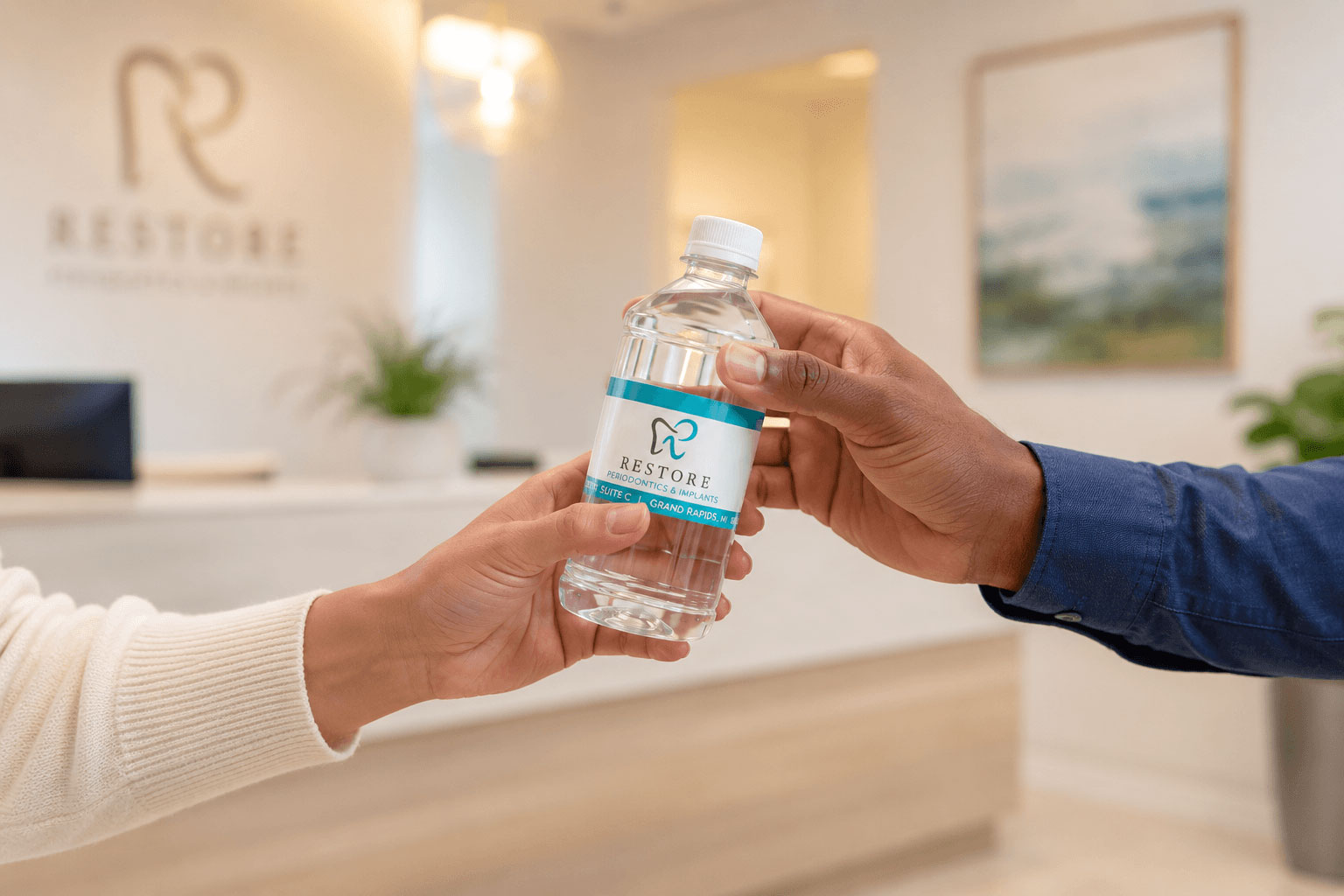 Restore Periodontics bottle handed from one person to another at the front desk